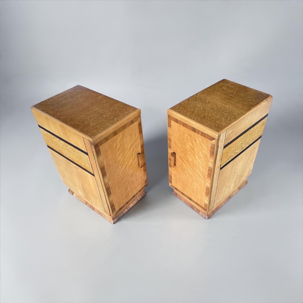 A matching pair of golden burr maple Art Deco bedside tables featuring single door cupboards with wooden block handles and plinth bases. View VIII