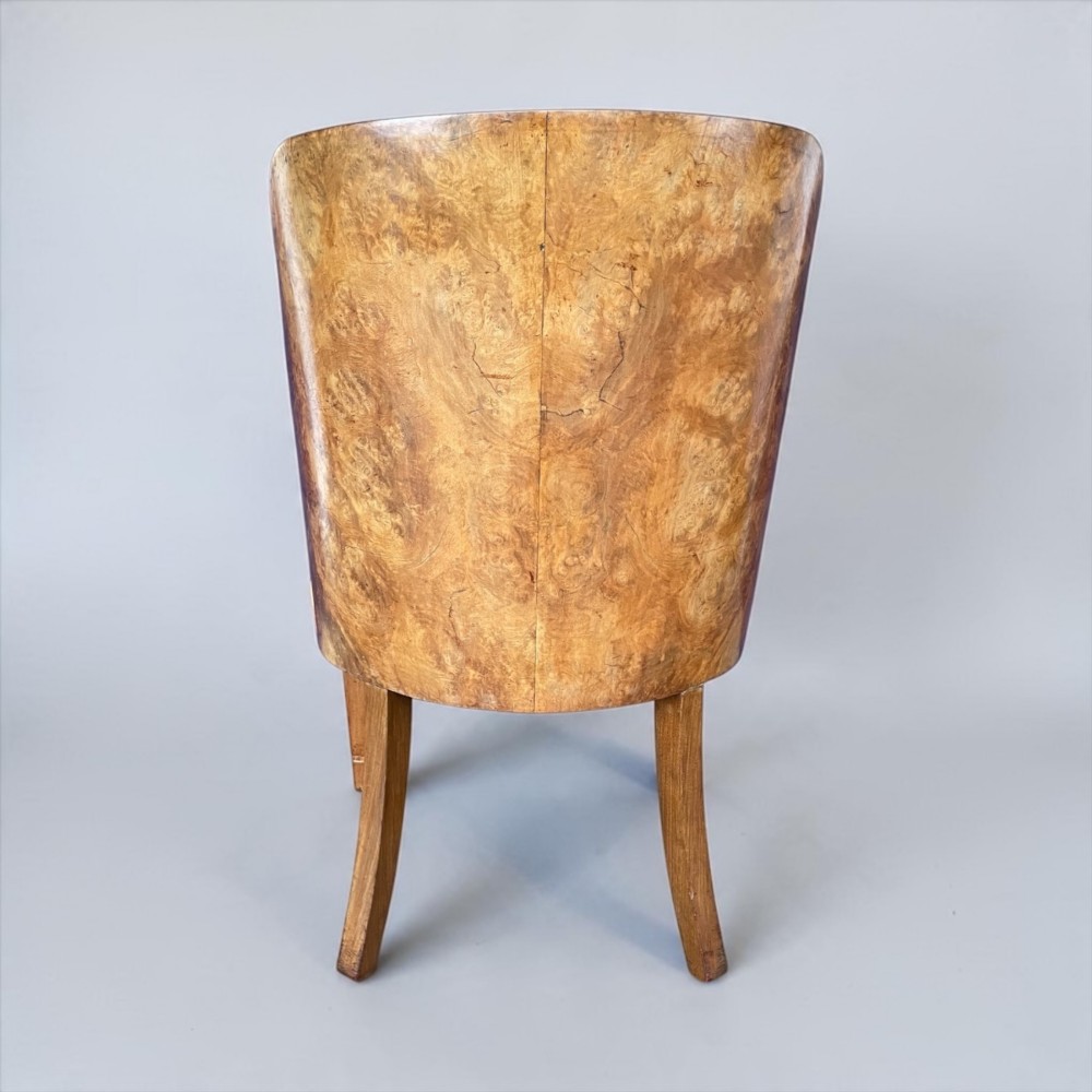An Art Deco armchair featuring a polished walnut wooden frame, geometric orange patterned upholstery, angular armrests, and tapered legs. View V