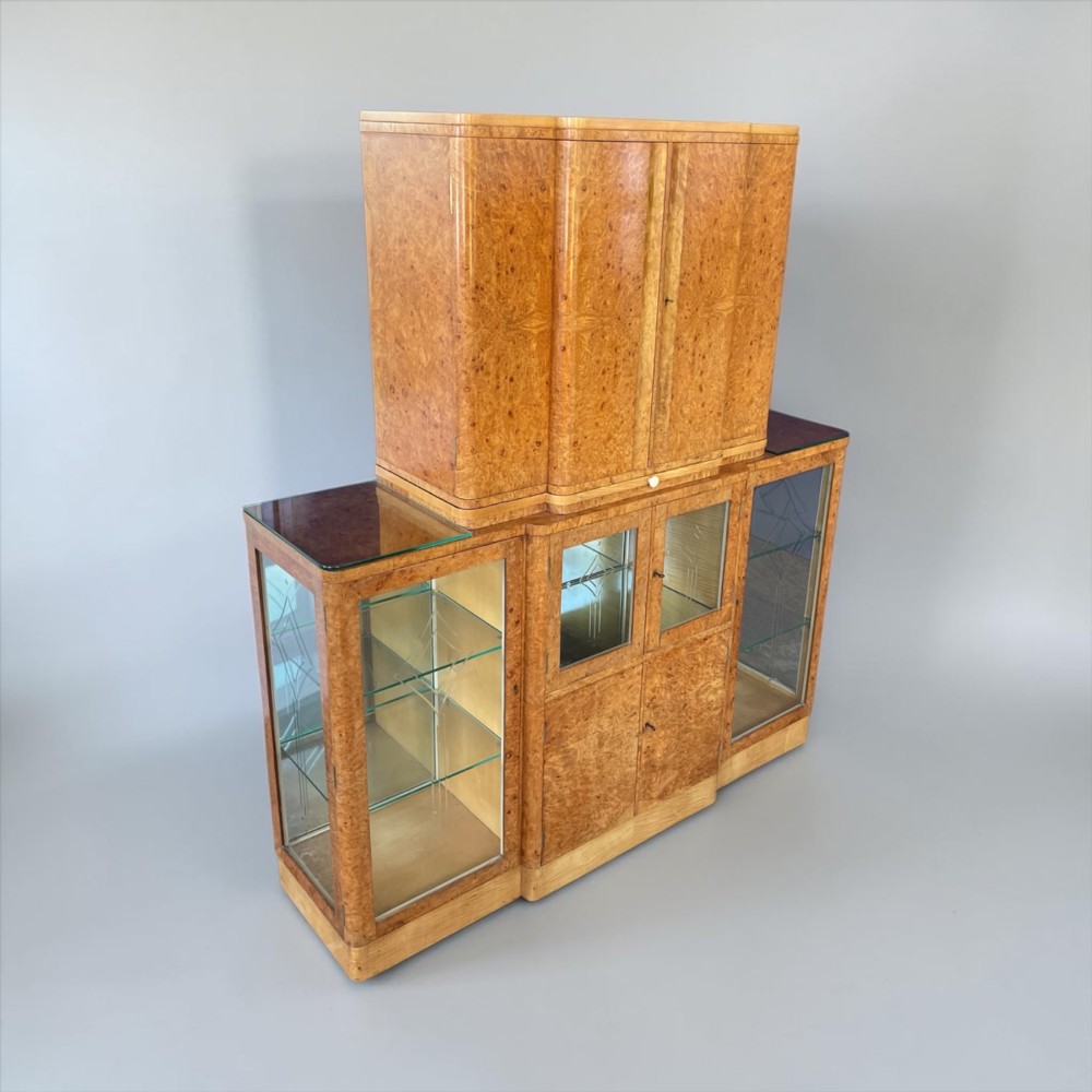 An Art Deco burr walnut cocktail cabinet with open upper doors revealing a mirrored interior, flanked by lower etched glass display sections. View III