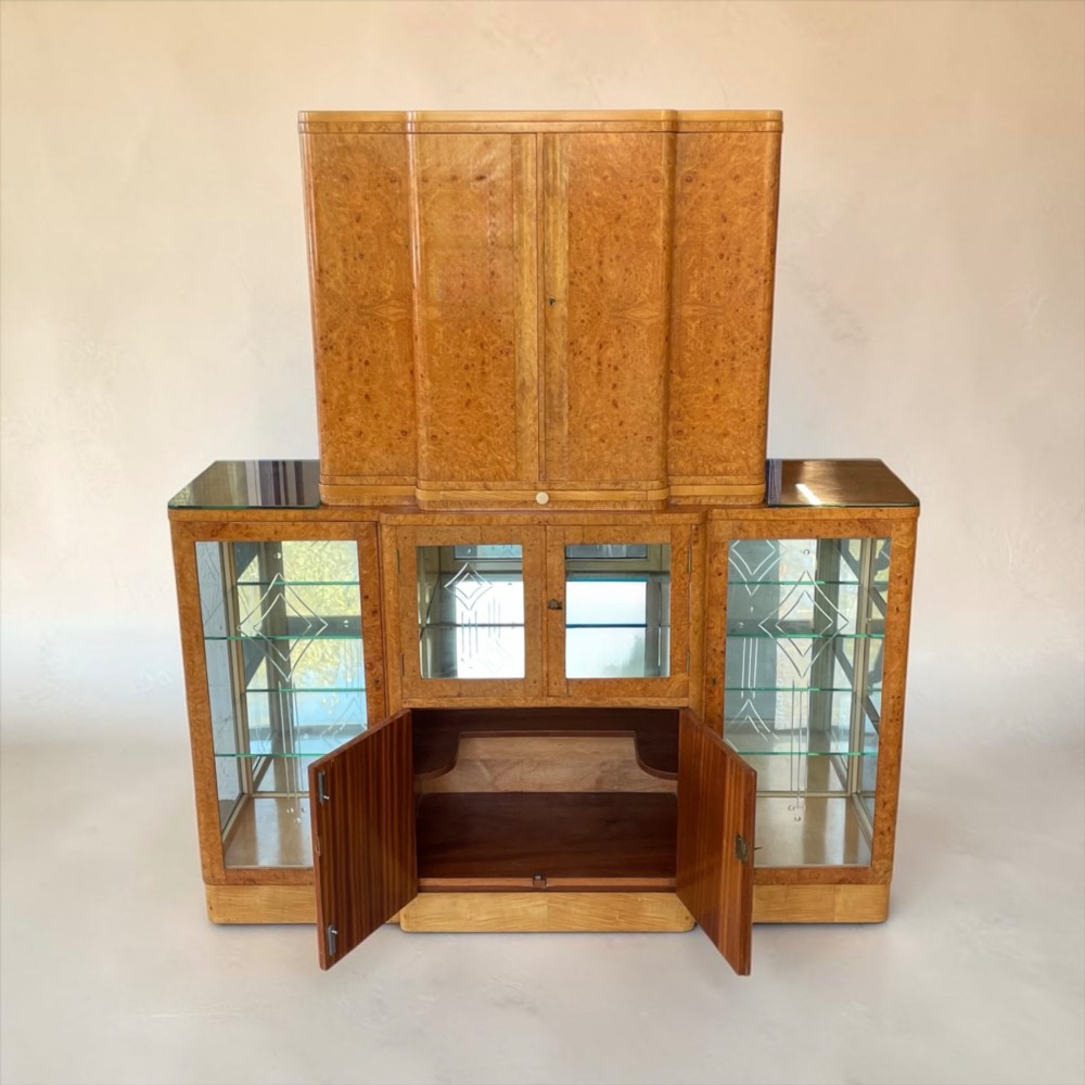 An Art Deco burr walnut cocktail cabinet with open upper doors revealing a mirrored interior, flanked by lower etched glass display sections. View V