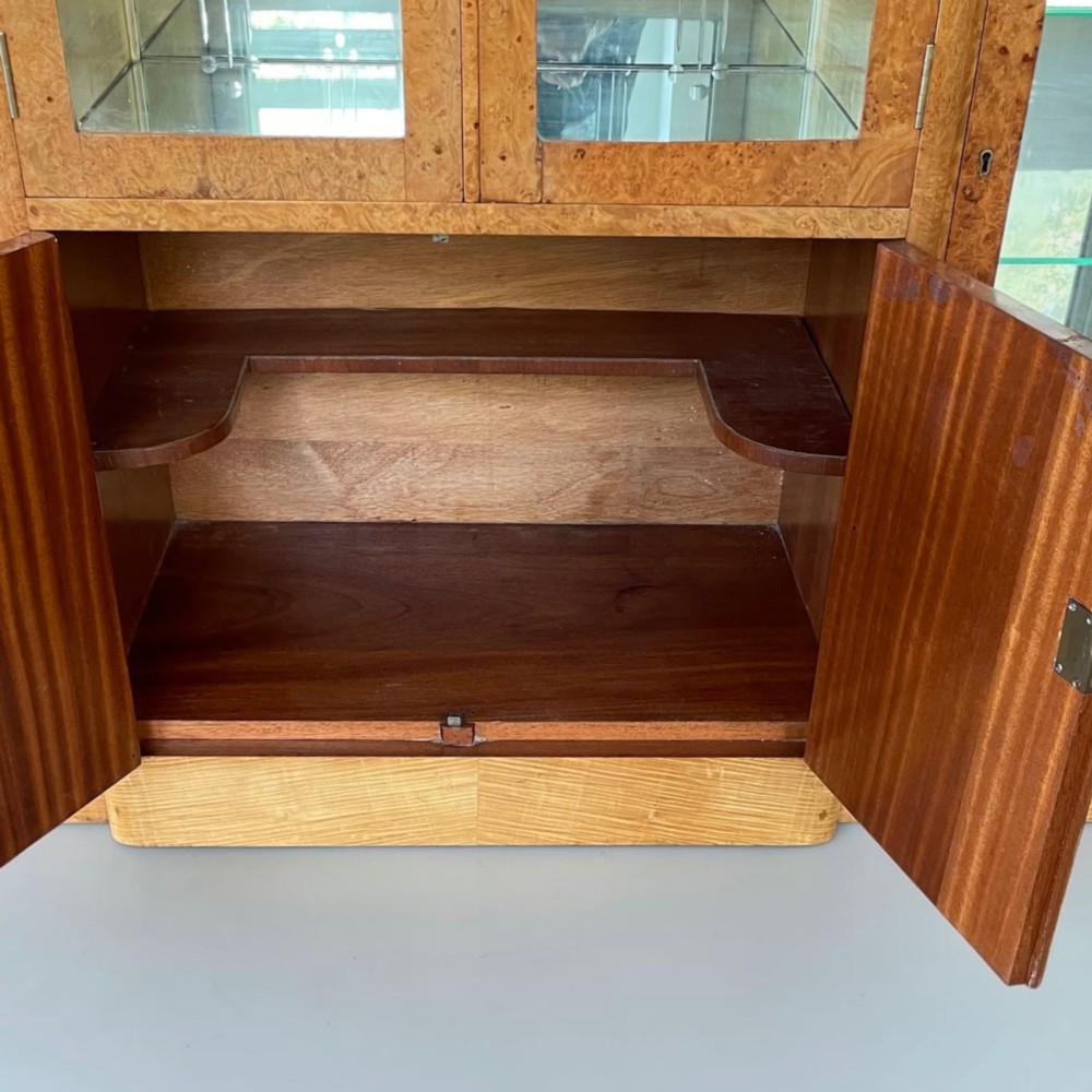 An Art Deco burr walnut cocktail cabinet with open upper doors revealing a mirrored interior, flanked by lower etched glass display sections. View VI
