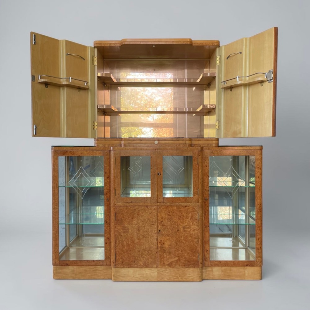 An Art Deco burr walnut cocktail cabinet with open upper doors revealing a mirrored interior, flanked by lower etched glass display sections. View X