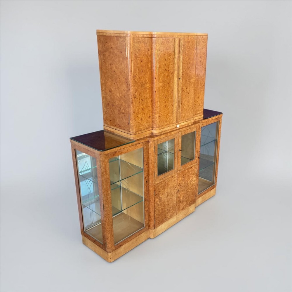 An Art Deco burr walnut cocktail cabinet with open upper doors revealing a mirrored interior, flanked by lower etched glass display sections. View XI