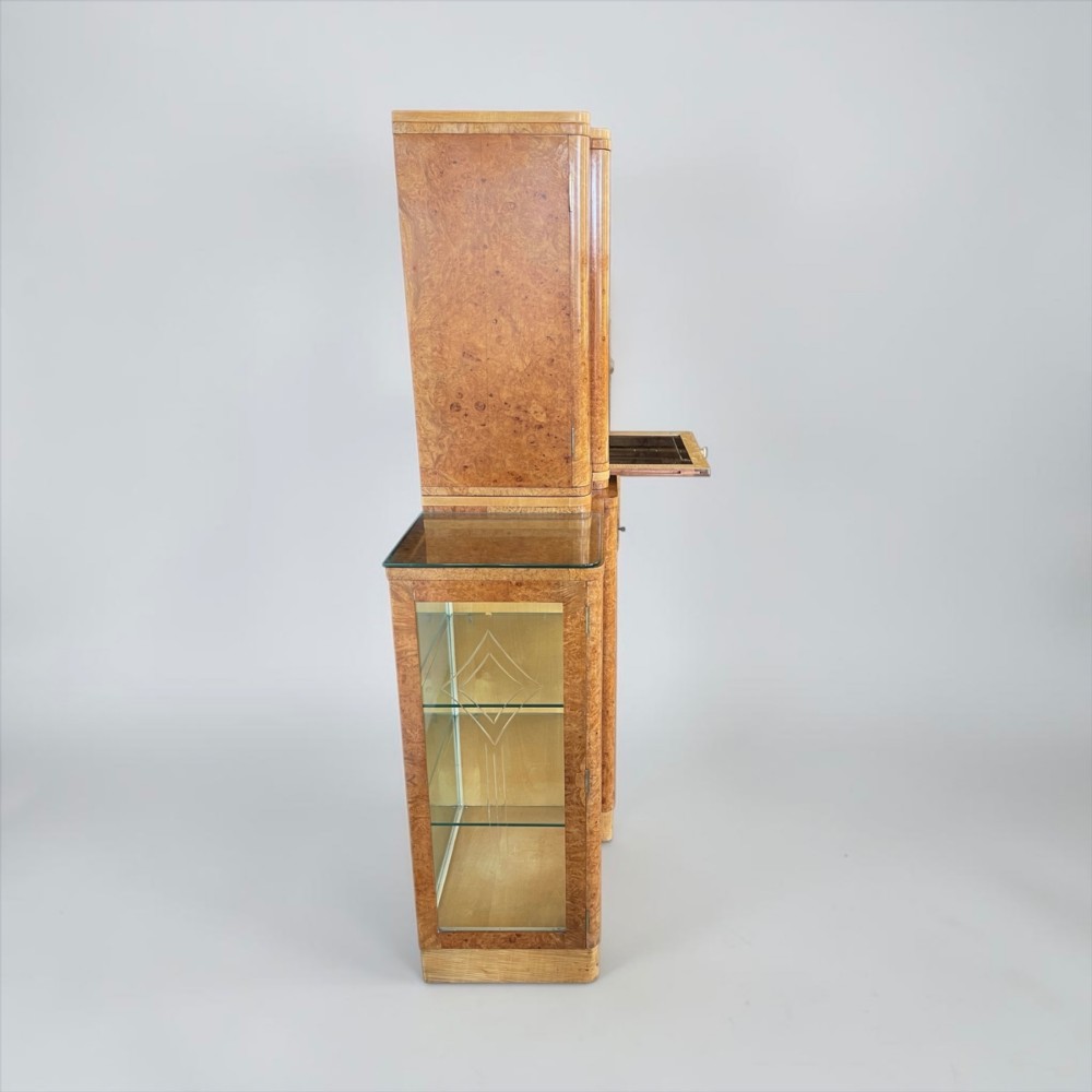 An Art Deco burr walnut cocktail cabinet with open upper doors revealing a mirrored interior, flanked by lower etched glass display sections. View XII