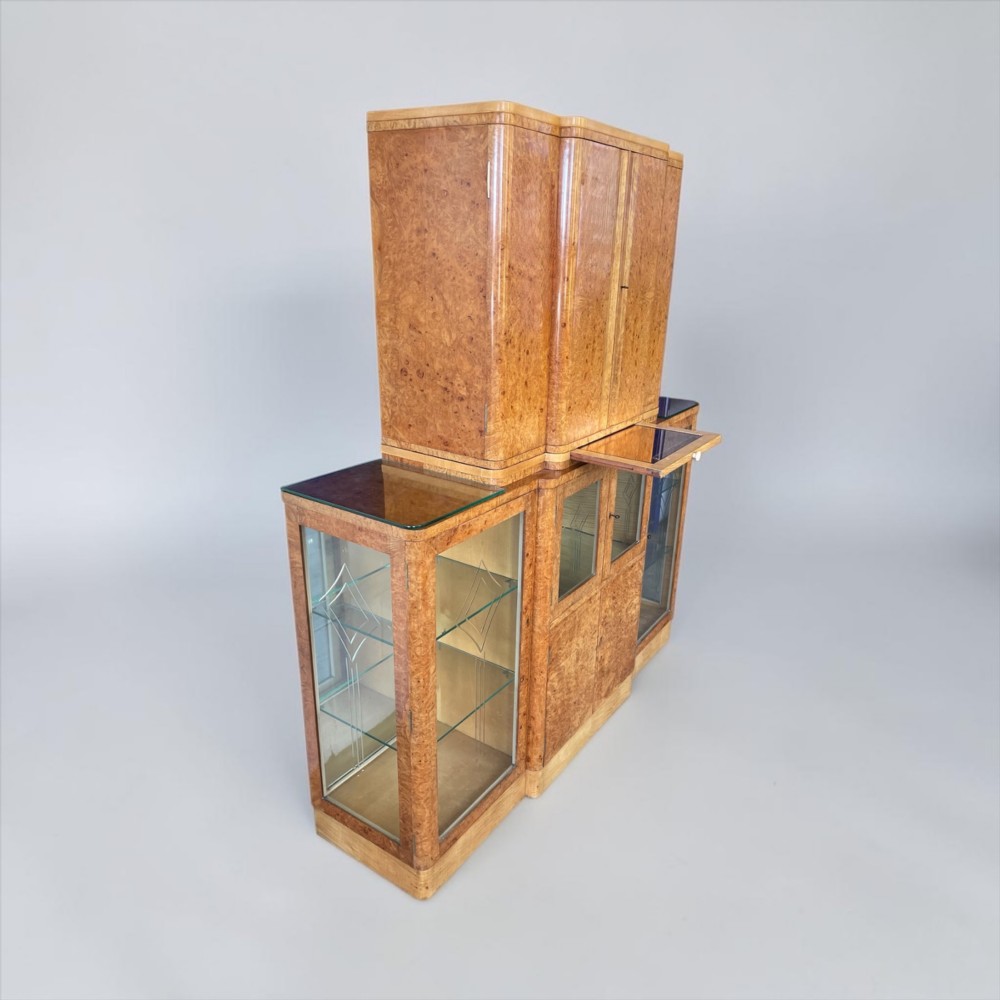 An Art Deco burr walnut cocktail cabinet with open upper doors revealing a mirrored interior, flanked by lower etched glass display sections. View XIII