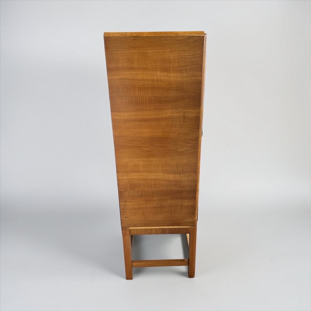 An Art Deco golden oak cabinet on stand featuring book-matched chevron wood veneers, two lower drawers, twin cupboard doors, and metal handles. View XIII