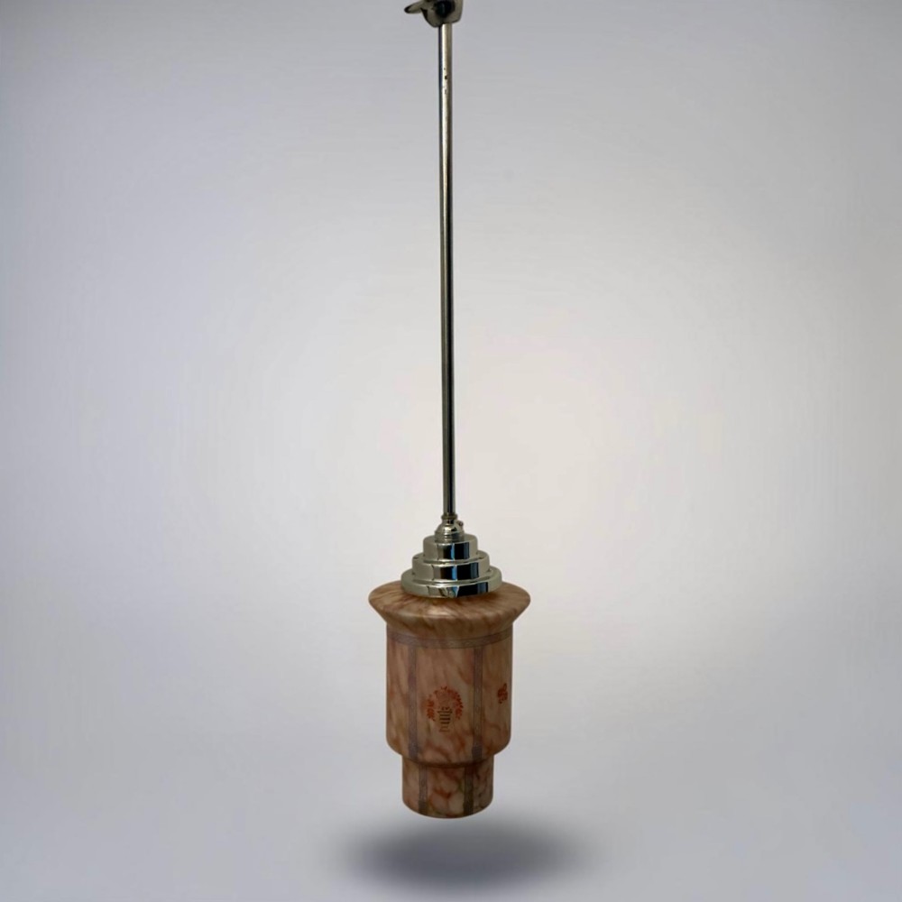 An Art Deco pendant light featuring a mottled pink glass shade with a stepped chrome gallery suspended from a central metal stem.