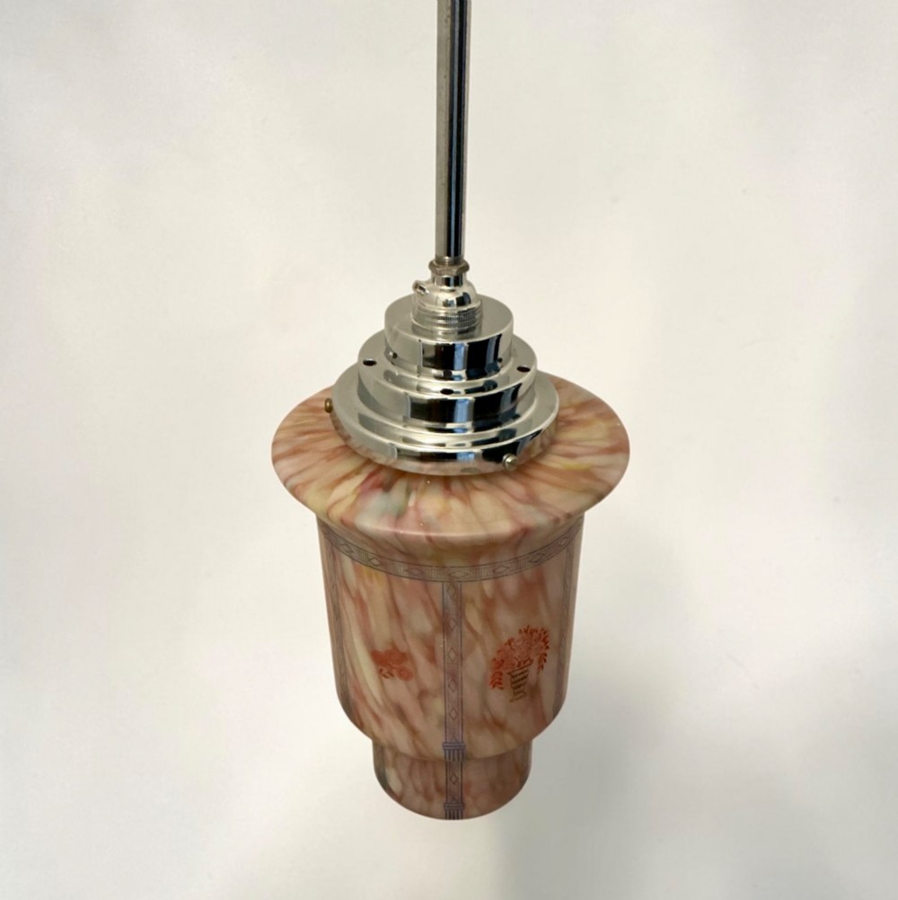 An Art Deco pendant light featuring a mottled pink glass shade with a stepped chrome gallery suspended from a central metal stem. View II