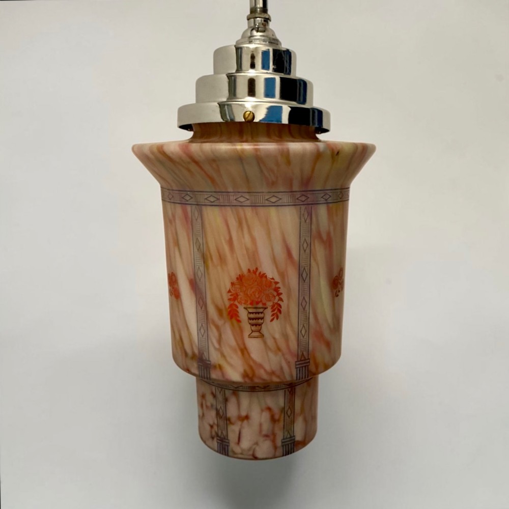 An Art Deco pendant light featuring a mottled pink glass shade with a stepped chrome gallery suspended from a central metal stem. View V