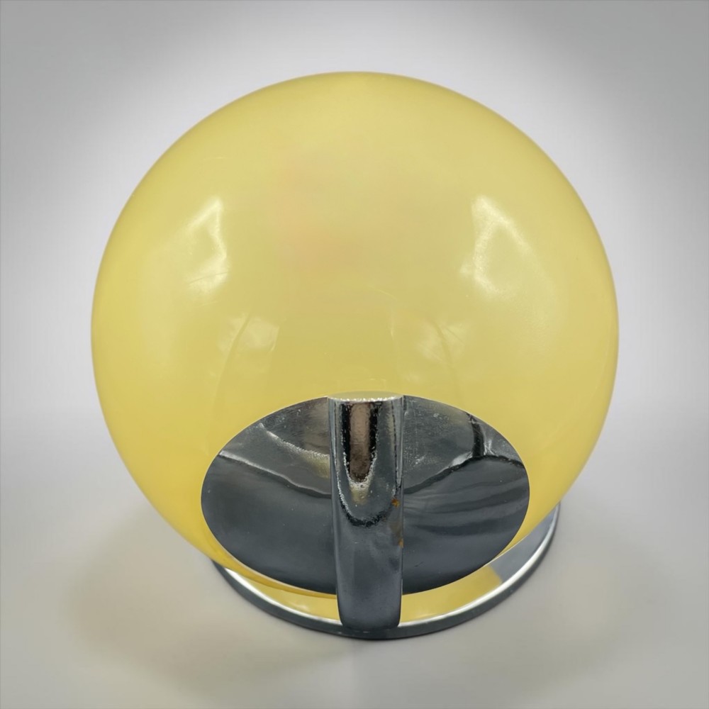 An Art Deco wall light featuring a circular yellow glass shade set within a stepped chrome mount. View II
