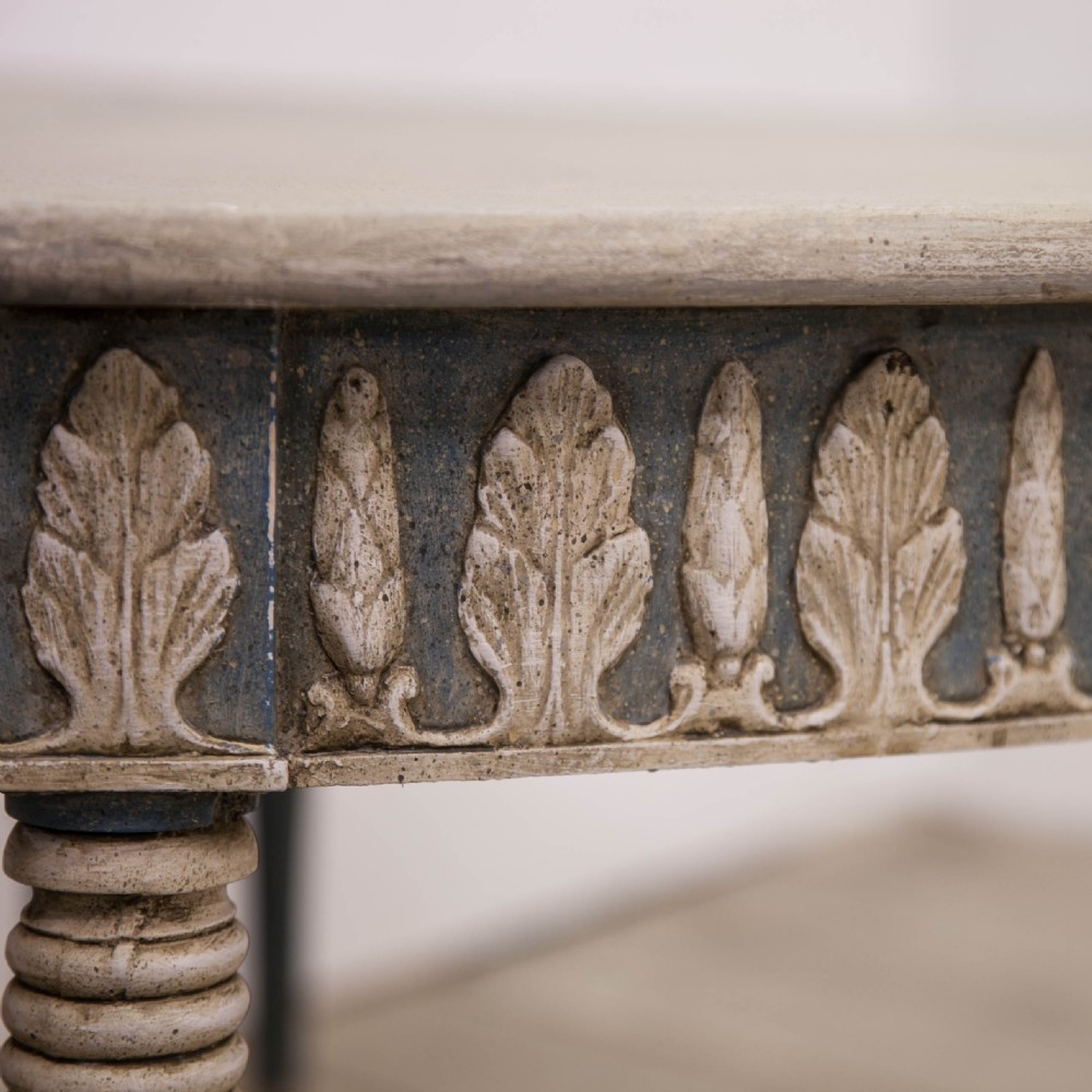 A pair of semi-circular Swedish Gustavian style console tables featuring grey and off-white painted finishes with carved leaf patterns around the apron and tapered legs. View II