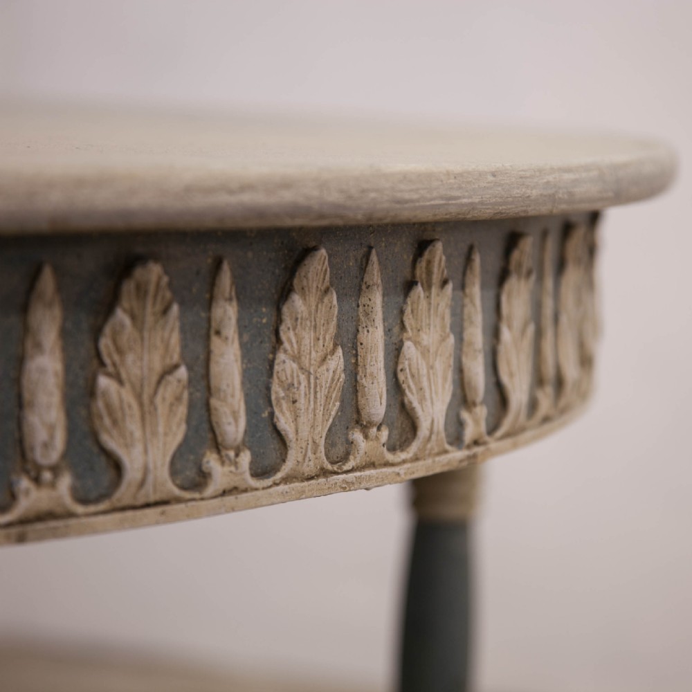 A pair of semi-circular Swedish Gustavian style console tables featuring grey and off-white painted finishes with carved leaf patterns around the apron and tapered legs. View VII