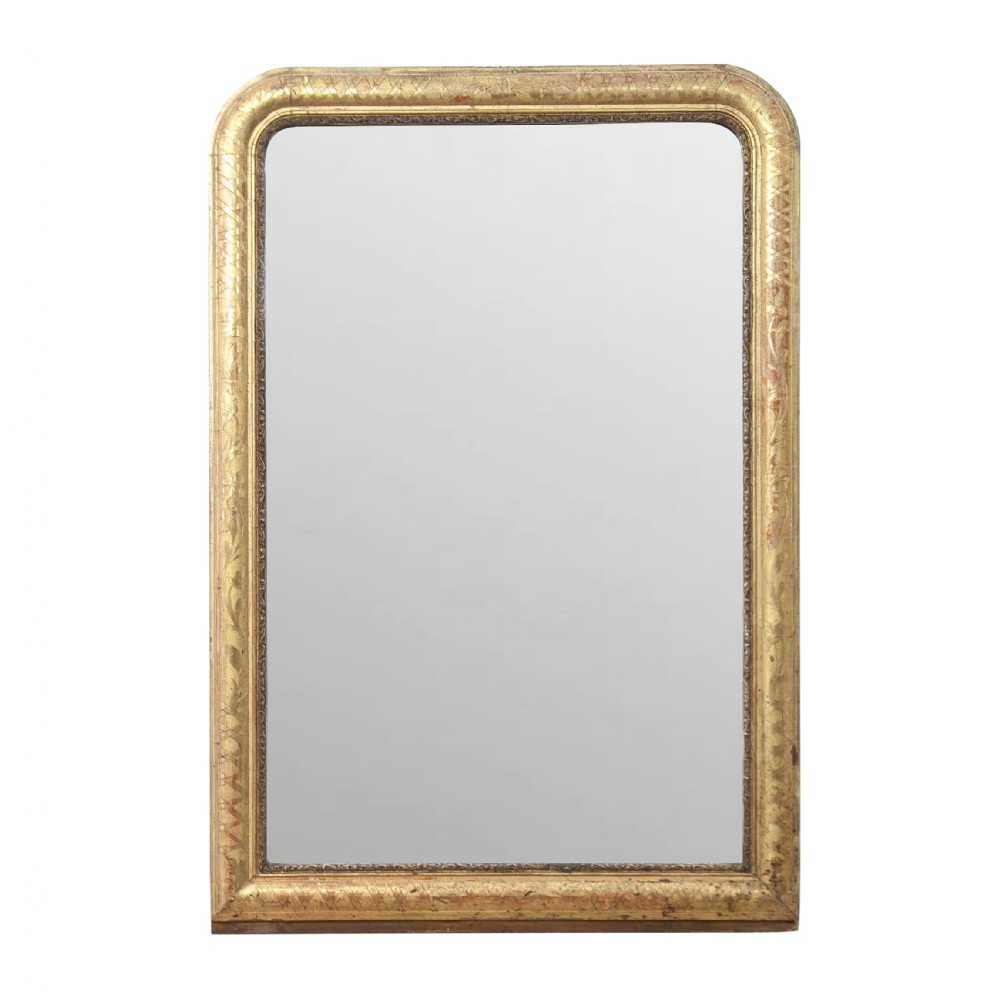 A rectangular Louis Philippe style mirror with rounded top corners, framed in an antique gold gilded wood moulding with incised geometric patterns.
