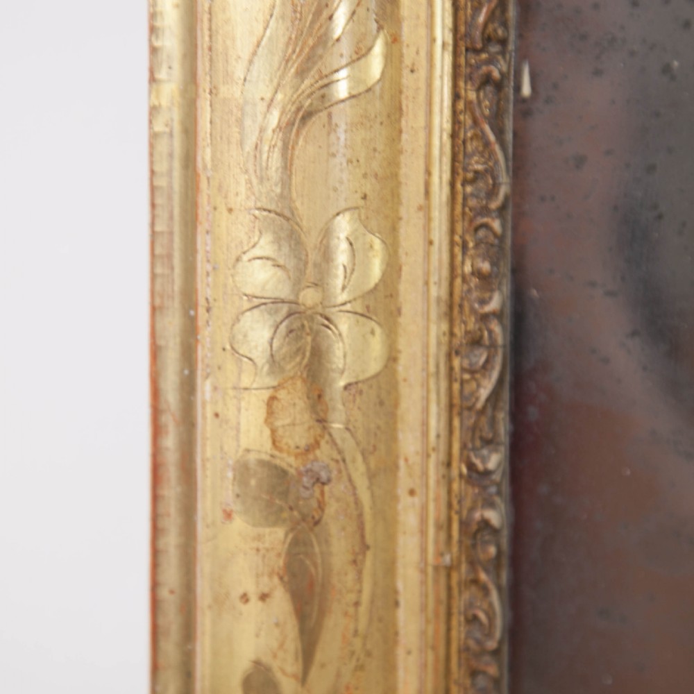 A rectangular Louis Philippe style mirror with rounded top corners, framed in an antique gold gilded wood moulding with incised geometric patterns. View IV