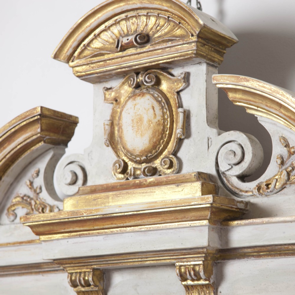 A matching pair of Neoclassical wall mirrors featuring cream painted frames with gilded pediments, scroll cresting, and rectangular mirror glass. View III