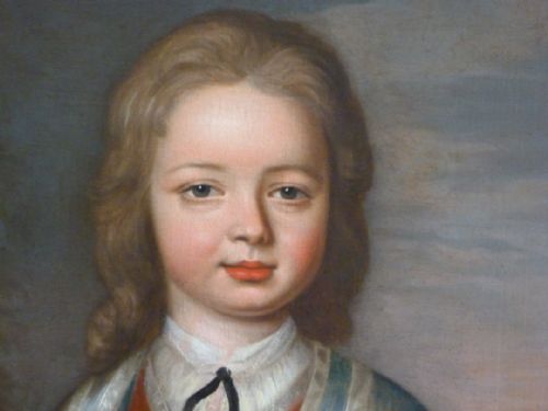 fig 2. An 18th-century oil portrait depicting a young boy in a red tunic and blue trimmed jacket, housed in an ornate carved gilded frame.