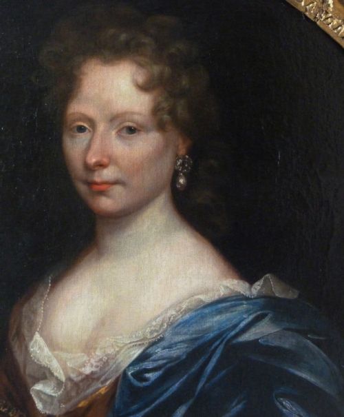 fig 1. An oval 17th-century oil painting depicting a noblewoman dressed in a blue drape and lace-trimmed gown within an ornate carved giltwood frame.