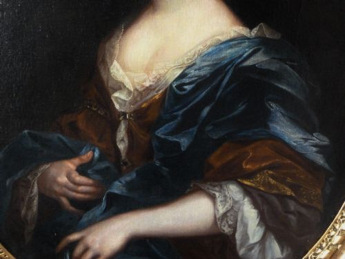 fig 2. An oval 17th-century oil painting depicting a noblewoman dressed in a blue drape and lace-trimmed gown within an ornate carved giltwood frame.