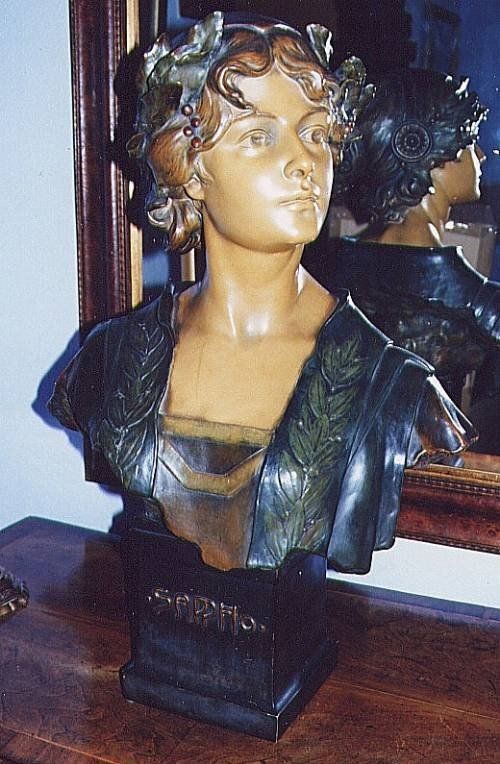 fig 1. An Art Nouveau sculpted portrait bust of the poet Sappho featuring dark bronzed drapery, warm ochre skin tones, and the inscription SAPPHO across the plinth.