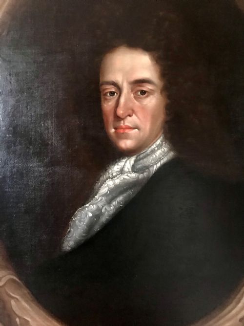 fig 1. A late 17th-century Scottish oil portrait depicting a gentleman with a dark full-bottomed wig and lace cravat set within a painted feigned oval and carved gilded wooden frame.