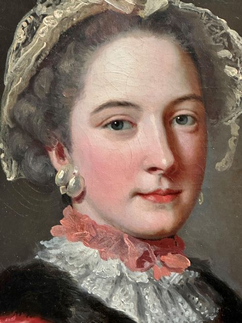 fig 2. An 18th-century oil painting of a lady wearing a pink embroidered dress and lace bonnet, set within a carved gold swept frame.
