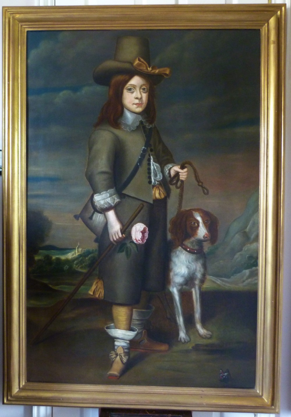 A full-length portrait depicting a figure in 17th-century costume alongside a spaniel, encased within a moulded gold gilt frame.