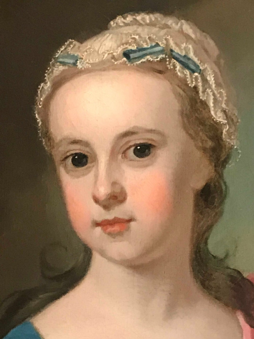 An 18th-century oil painting on canvas depicting a young girl in a blue dress and pink mantle feeding leaves to a deer, set within a carved giltwood frame. View IV