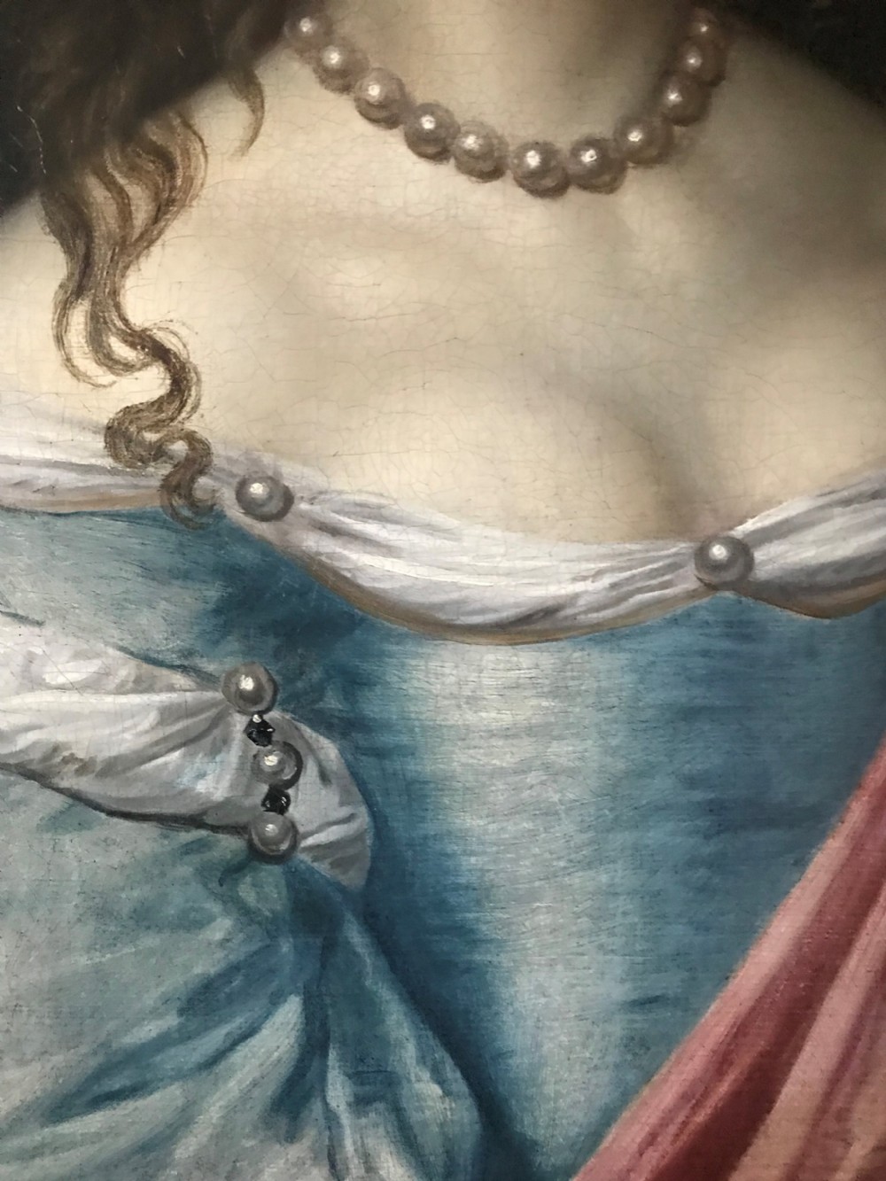 An antique seventeenth-century oil portrait of a noblewoman in a blue dress and pearl jewellery set within an ornate carved giltwood frame. View IV