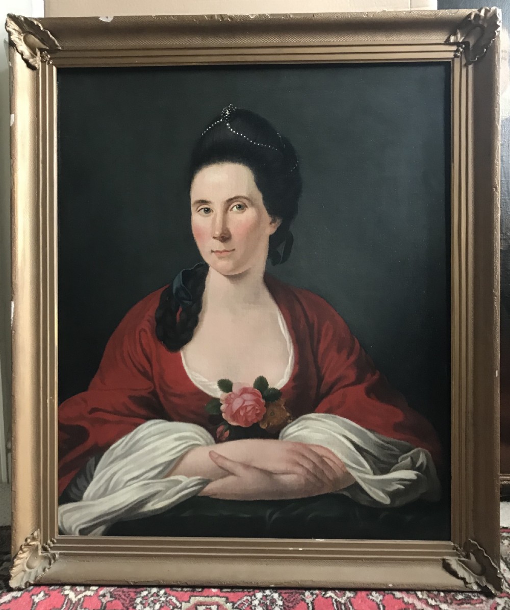 An 18th-century oil portrait painting of a lady wearing a red dress with a pink floral corsage, displayed within a moulded giltwood frame.