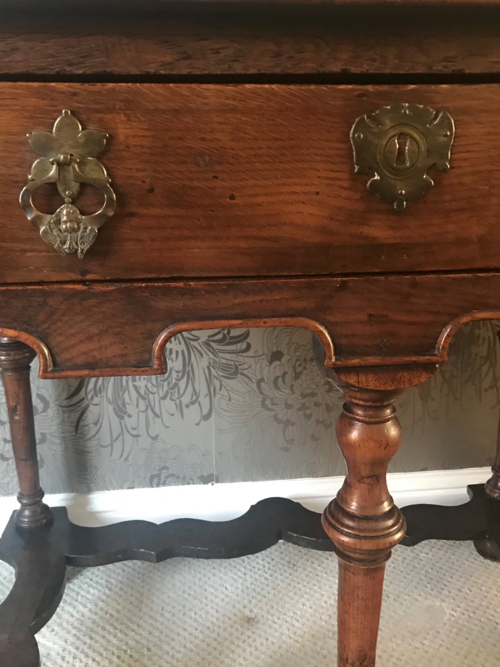 A dark oak side table with a single drawer featuring brass drop handles, a shaped apron, turned baluster legs, and a wavy stretcher base. View II