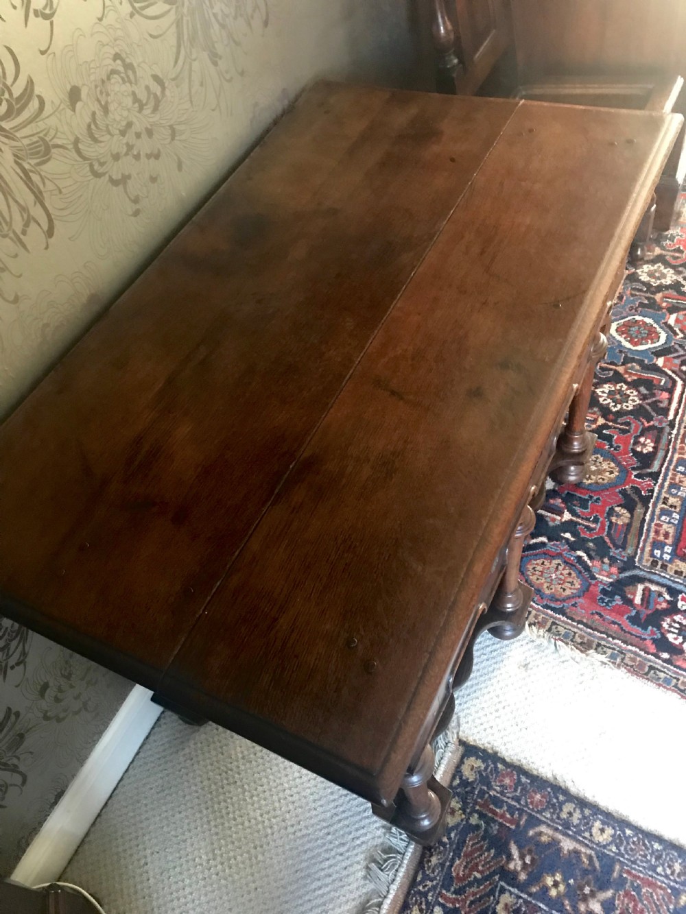 A dark oak side table with a single drawer featuring brass drop handles, a shaped apron, turned baluster legs, and a wavy stretcher base. View V