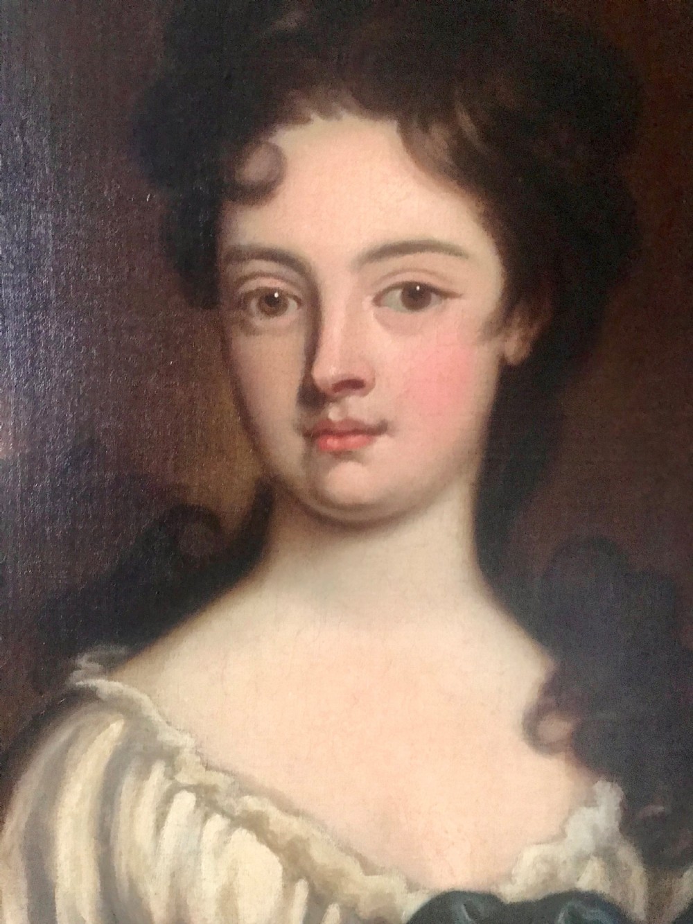 An 18th-century oil portrait painting of a woman in a white gown with a blue drape, set within a carved gold gilt frame. View III
