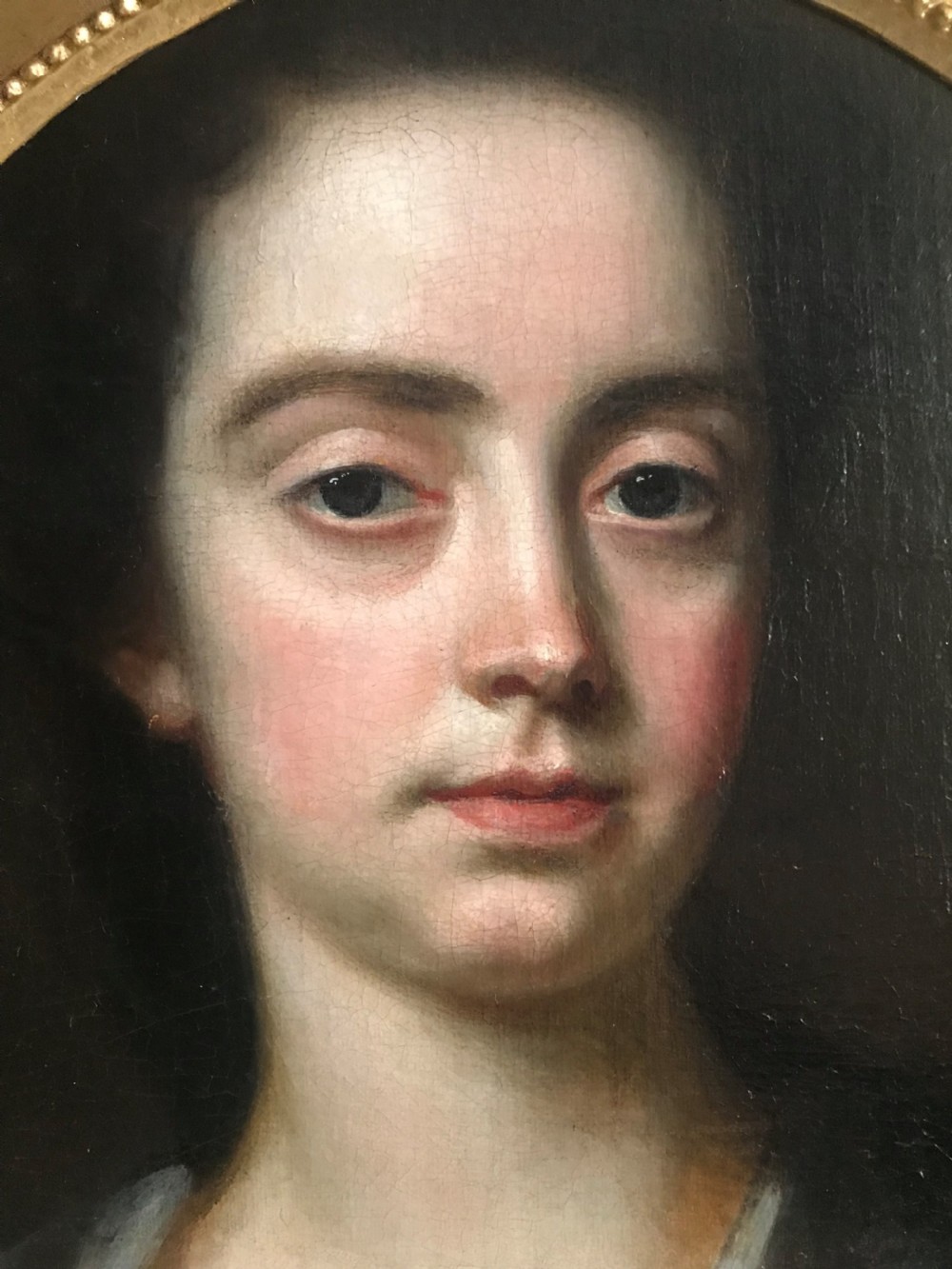 An 18th-century oil portrait of a lady in a white gown and blue mantle, framed by a feigned oval inside an ornate gold rectangular frame. View III