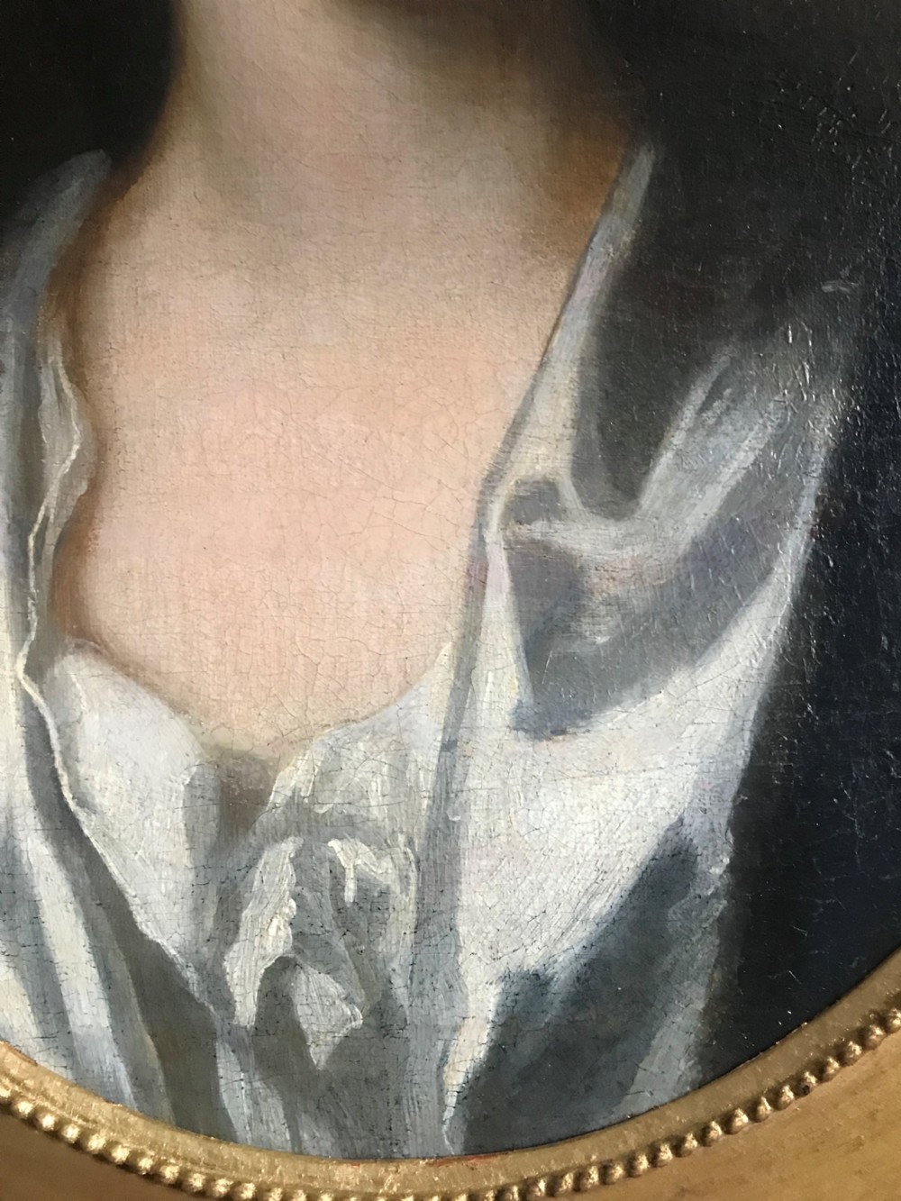 An 18th-century oil portrait of a lady in a white gown and blue mantle, framed by a feigned oval inside an ornate gold rectangular frame. View IV