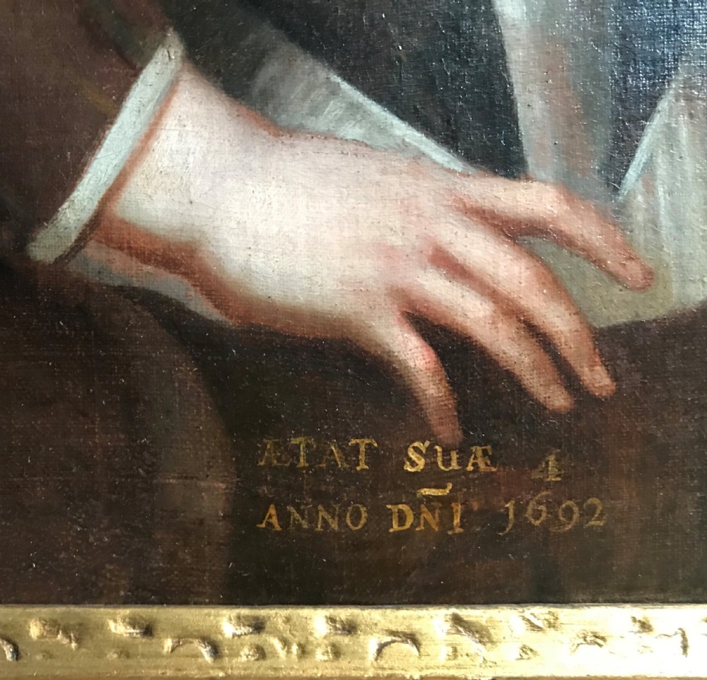 An antique seventeenth-century oil portrait of a young boy with light brown hair in period dress, set in a carved gilt frame. View IV