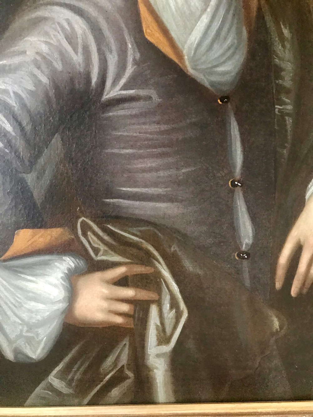 An antique oil portrait of a young man wearing a grey coat and white cravat, encased in a carved giltwood frame. View IV