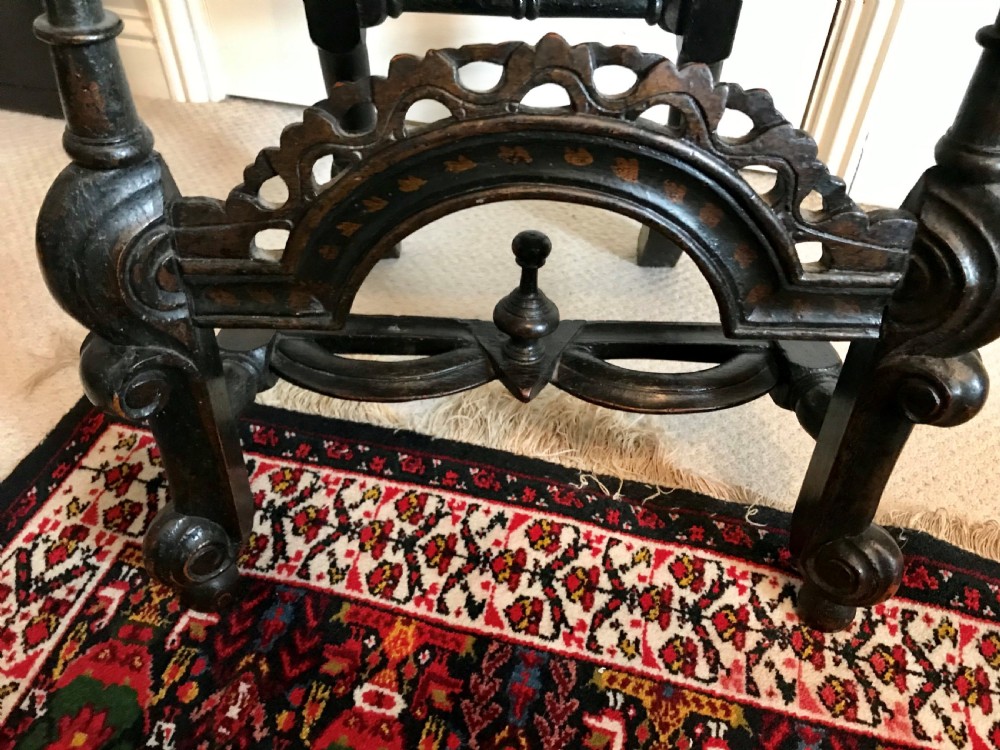 A tall-backed black japanned side chair featuring a cane seat panel, a central woven cane splat, turned uprights, and carved cresting. View IV