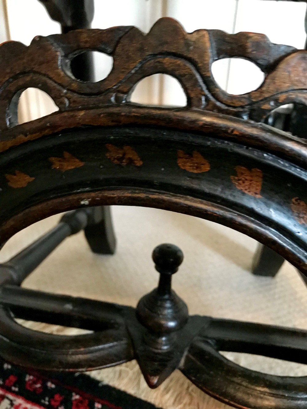 A tall-backed black japanned side chair featuring a cane seat panel, a central woven cane splat, turned uprights, and carved cresting. View V