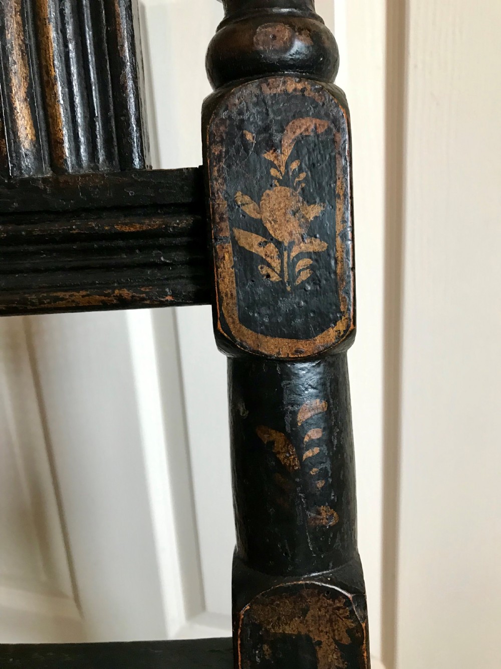 A tall-backed black japanned side chair featuring a cane seat panel, a central woven cane splat, turned uprights, and carved cresting. View VI