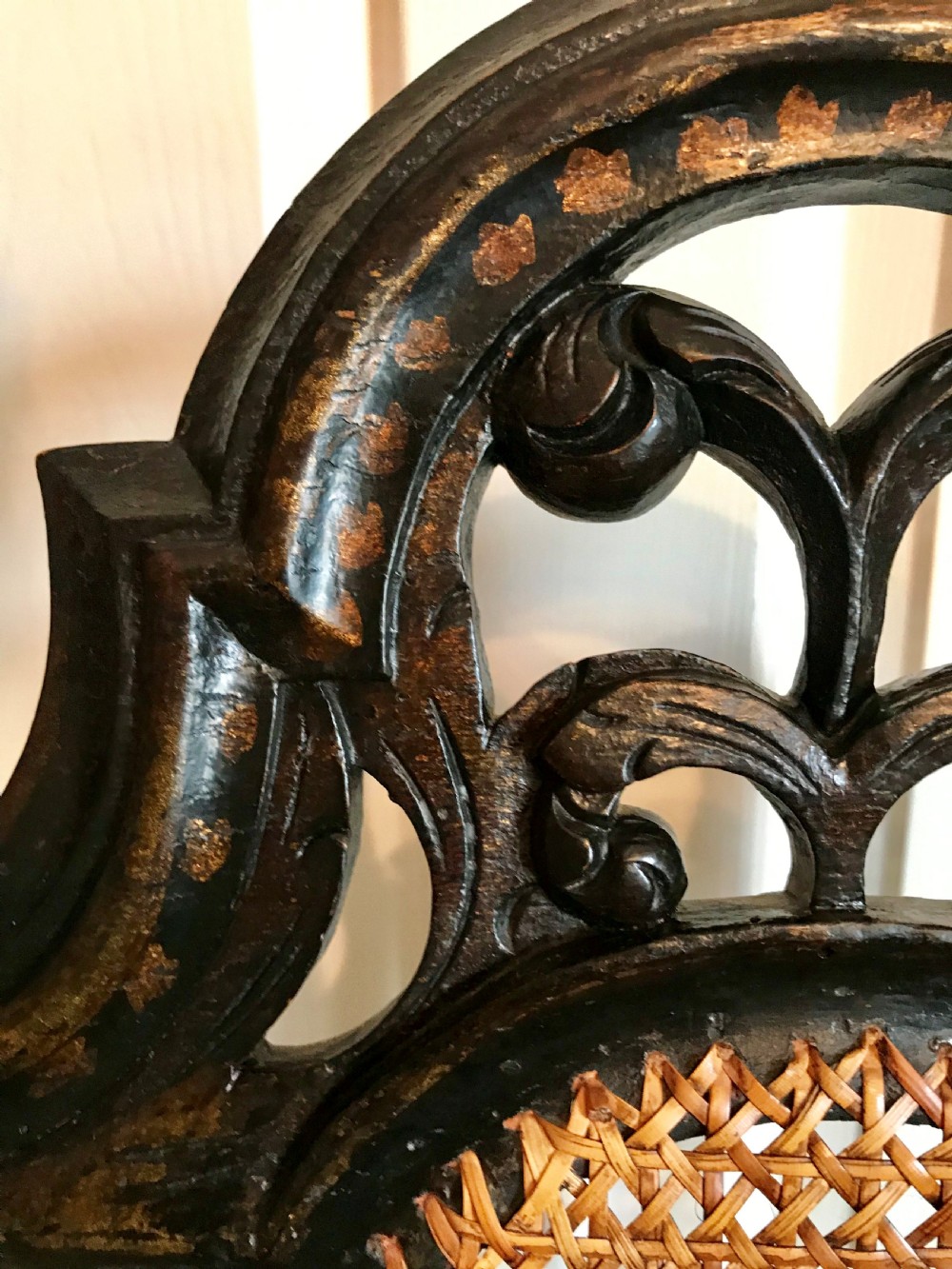 A tall-backed black japanned side chair featuring a cane seat panel, a central woven cane splat, turned uprights, and carved cresting. View VII