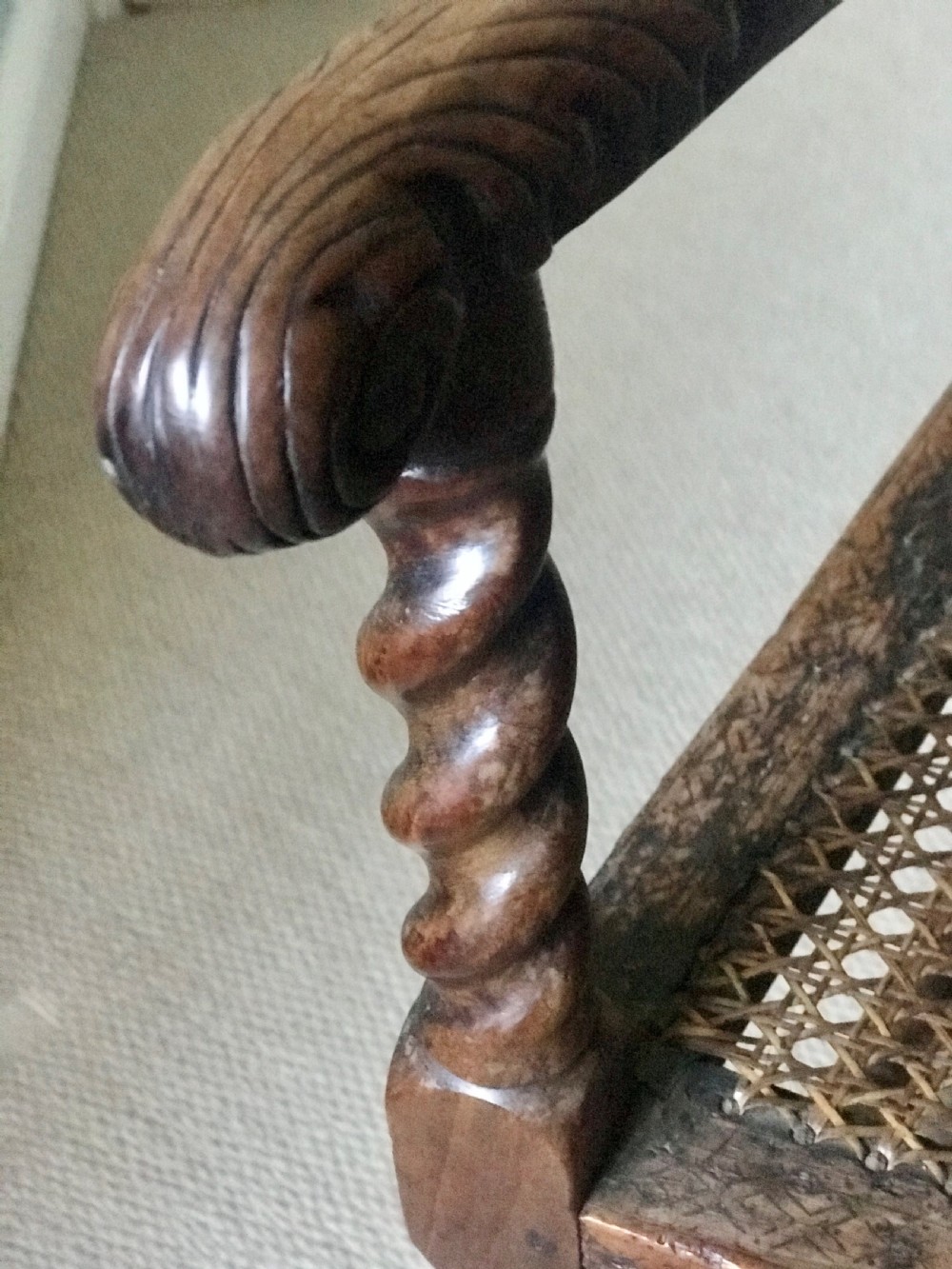 A 17th-century James II carved walnut armchair featuring spiral barley-twist uprights, detailed foliate carving, a central shell cresting, and woven cane back panel and seat. View V