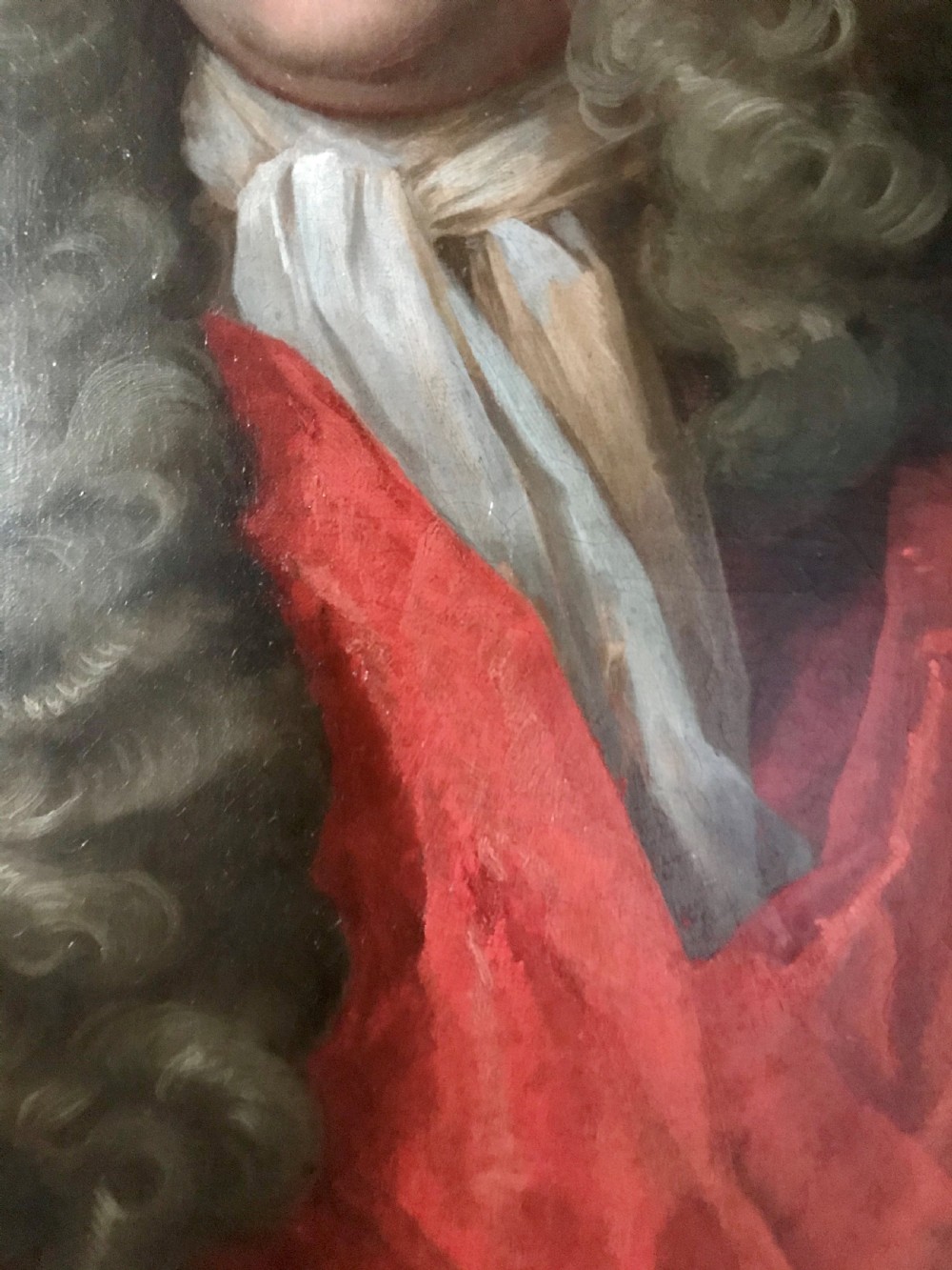 An oval oil portrait of a gentleman in a long powdered wig and red drapery, housed within a carved giltwood frame. View III