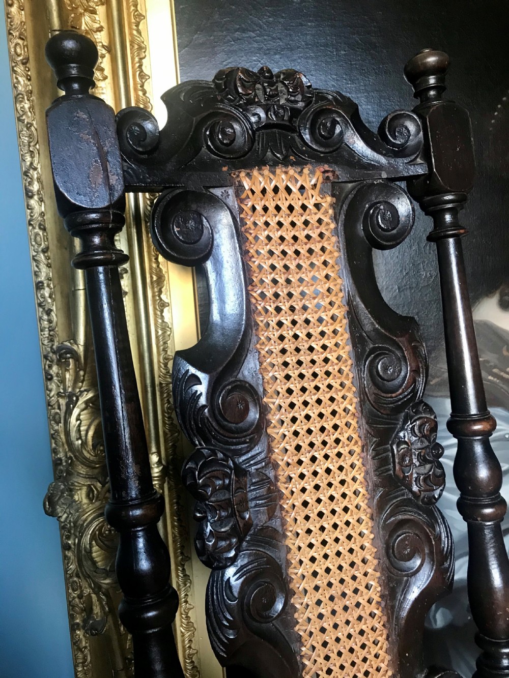 A late 17th-century dark carved beech side chair featuring a tall back with scrollwork, turned supports, and woven cane panels. View II