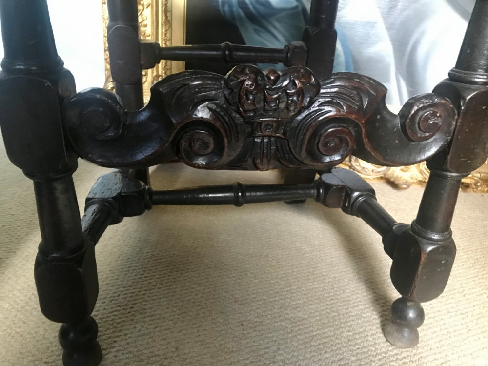 A late 17th-century dark carved beech side chair featuring a tall back with scrollwork, turned supports, and woven cane panels. View IV