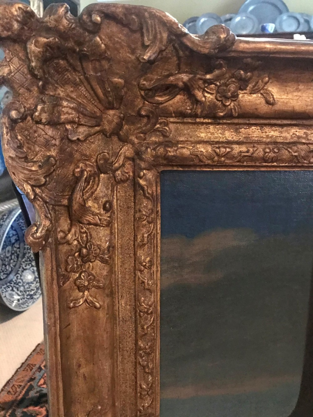 A seventeenth-century oil painting depicting a young gentleman in brown drapery and lace cravat set in a deeply carved giltwood frame. View IV
