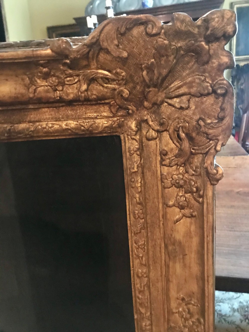 A seventeenth-century oil painting depicting a young gentleman in brown drapery and lace cravat set in a deeply carved giltwood frame. View V