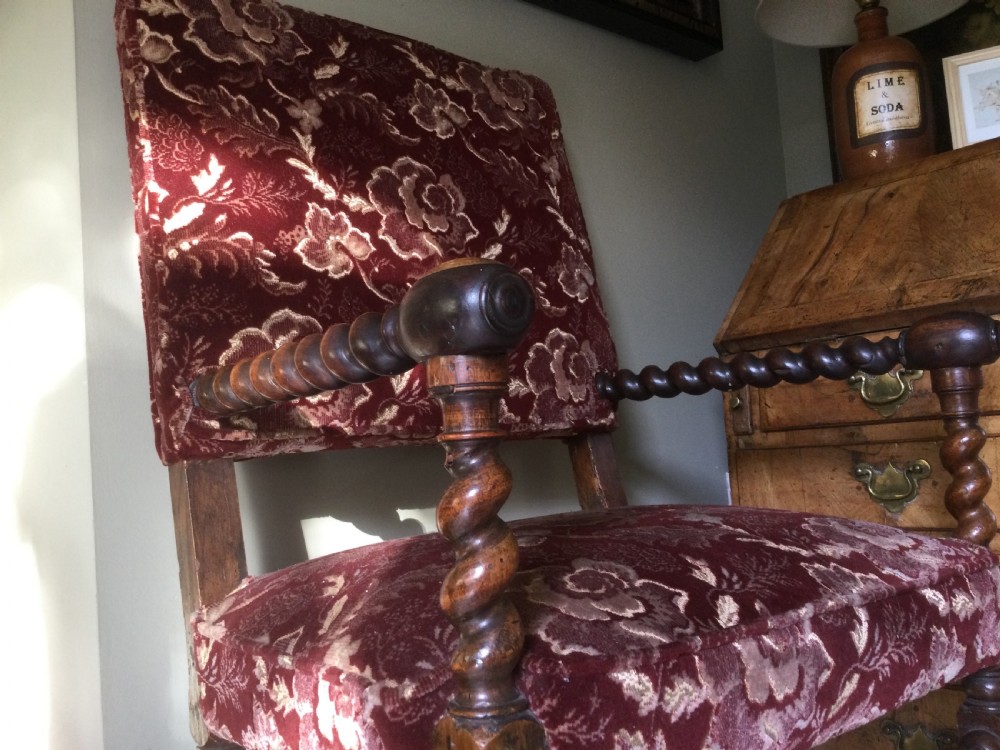 A 17th-century Carolean open armchair made from laburnum wood with spiral barley twist turnings and crimson patterned velvet upholstery. View V