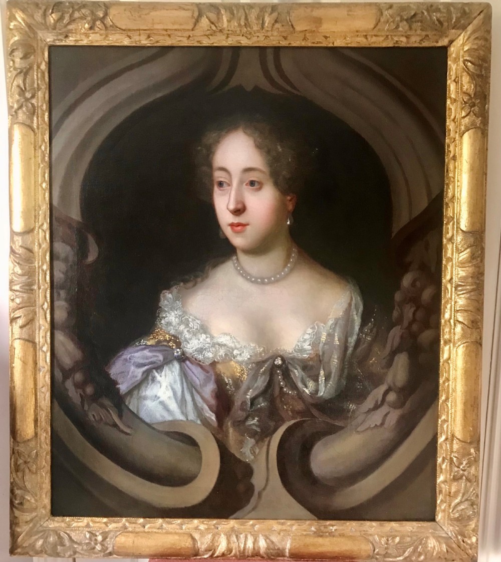 An oil portrait of a 17th-century lady with brown hair wearing a pearl necklace and draped gown, presented within a carved gold leaf frame.