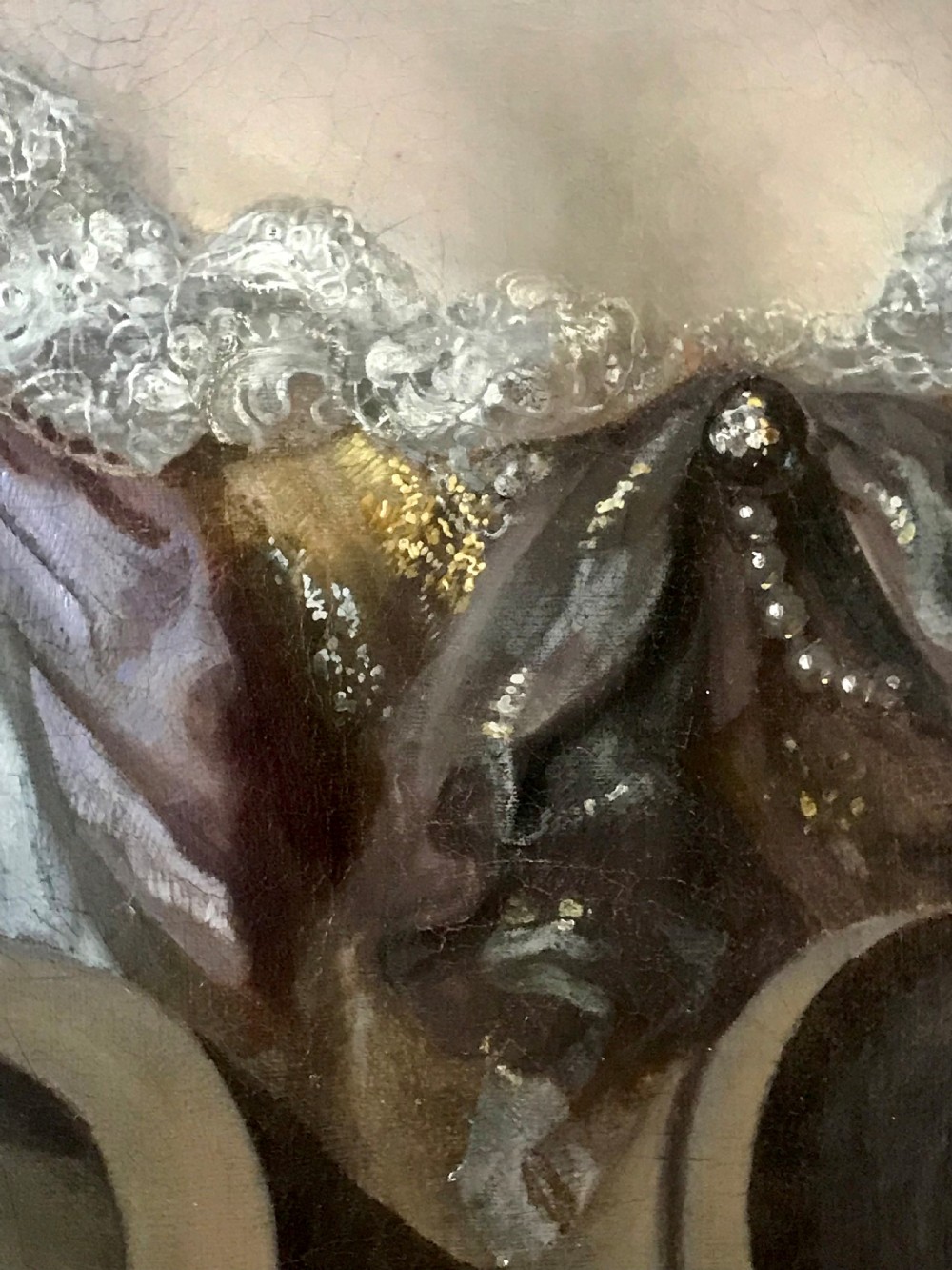 An oil portrait of a 17th-century lady with brown hair wearing a pearl necklace and draped gown, presented within a carved gold leaf frame. View III