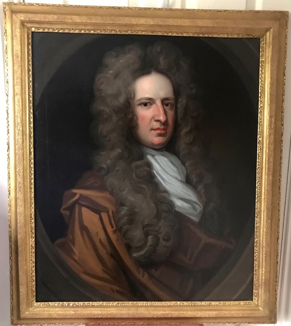 A seventeenth-century oil portrait depicting a gentleman with a large curling periwig and white cravat set inside a feigned oval within a gilded frame.